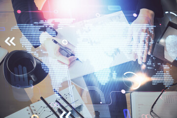 Multi exposure of hands making notes with world map hologram and data theme icons. Concept of global data.