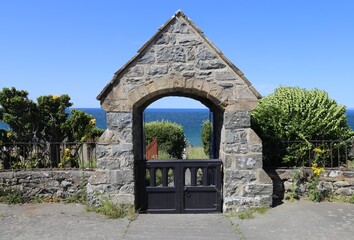 Obraz premium The lychgate to St. Mary and St. Bodfan's Church beside Cardigan Bay, at Llanaber, Wales, UK.