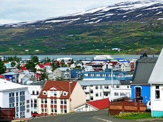 scenic cityscape downtown of Akureyri city. Idyllic peaceful cozy capital of Northern Iceland. Colorful urban landscape. Mountain Sulur shield town from strong winds.