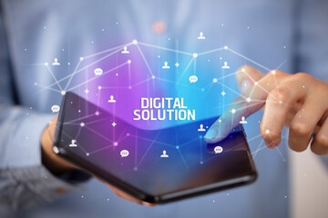 Businessman holding a foldable smartphone with DIGITAL SOLUTION inscription, new technology concept