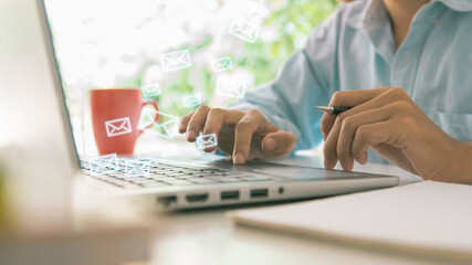 newsletter concept Hand of a businessman checking message box on the digital laptop with a red cup...