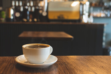 Soft focus blur Hot coffee cup of black,coffee on wooden table in the morning.