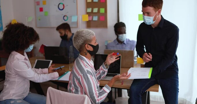 Young people working inside coworking office while wearing protective masks for coronavirus spread prevention - Slow Motion