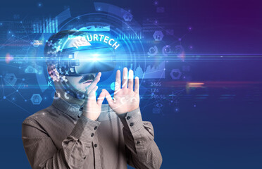 Businessman looking through Virtual Reality glasses with INSURTECH inscription, innovative technology concept