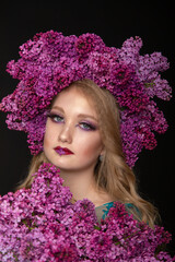 Beautiful teen girl on a dark background with beauty makeup in a smart dress with lilac