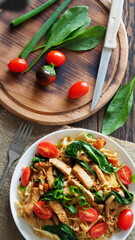 Pasta with fresh tomatoes and spinach leaves with fried turkey pieces