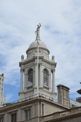 Fototapeta na wymiar The white tower of City Hall in New York under a slightly cloudy blue sky