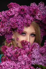 Naklejka premium Beautiful teen girl on a dark background with beauty makeup in a smart dress with lilac