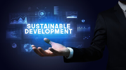 Hand of Businessman holding SUSTAINABLE DEVELOPMENT inscription, business success concept