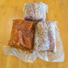 Marinated pork loin in vacuum packaging on a wooden table