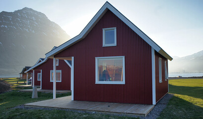 Red recreational wooden holiday houses on Iceland with green lawn and blue sky