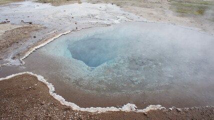 Hot spring geyser lake with steaming water on Iceland 