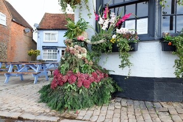Scarecrow entitled thank goodness for flowers, outside country pub