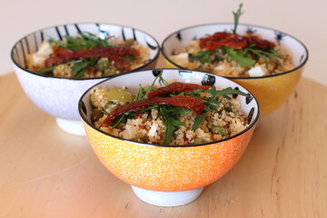 Cous cous con pomodori secchi, piselli, olive e feta