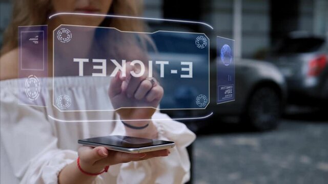 Unrecognizable blonde woman standing on the street interacts HUD hologram with text E-ticket. Girl in white clothes uses technology of the future mobile screen