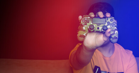 Male hands with game joystick, gamepad. The young guy is playing the console. Close up of man hands playing the video game at home. 