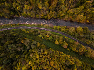 Winding Road and River in Autumn Forest. Aerial Drone Top Down View. Bieszczady in Poland