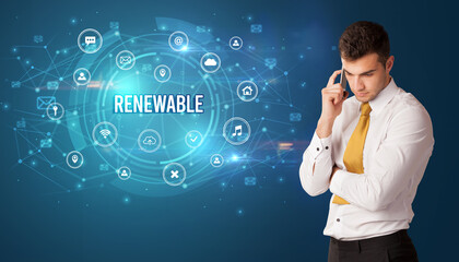 Businessman thinking in front of technology related icons and RENEWABLE inscription, modern technology concept