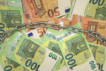 Euro Bargeld in Ketten als Zeichen f&uuml;r die Bargeldabschaffung.