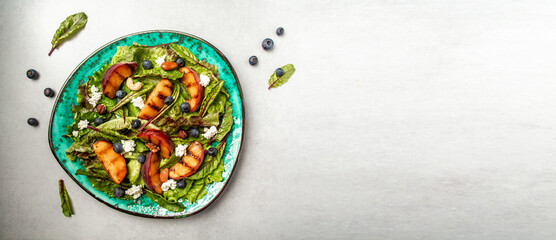 Delicious summer salad with caramelized peaches, blueberry and goat cheese. Food recipe background. Close up