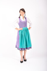 young brunette woman in  bavarian dirndl standing on white background