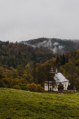 Lopienka Orthodox Church in Bieszczady Mountains. Fall Season in Mountains. Fog and Mist over COlorful Trees