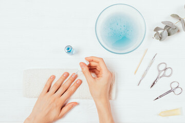 Female hands apply nail polish near set of tools