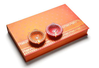 An indian sweet box with two lamps placed on it.