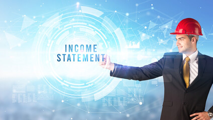Handsome businessman with helmet drawing INCOME STATEMENT inscription, contruction business concept