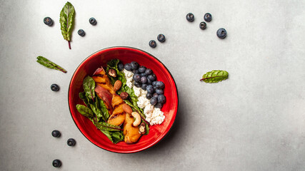 Healthy vegetarian salad. Summer peach salad with goat cheese, nuts and blueberry. healthy vegetarian lunch bowl. Long banner format, top view