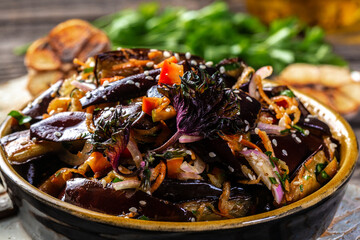 Grilled eggplant salad with, paprika, carrot, onion and garlic on a light background, Vegan food