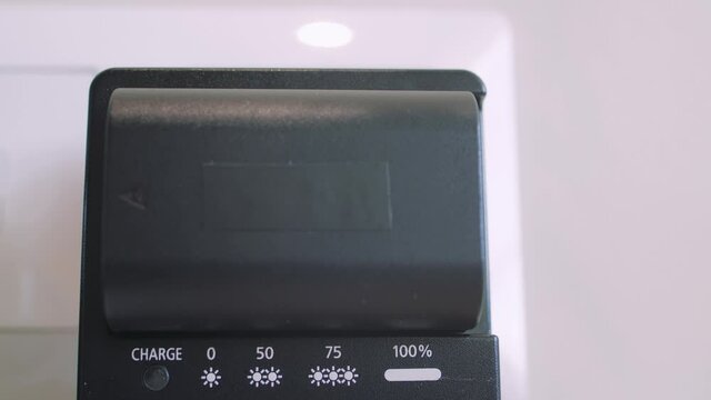 Man hand instaling battery on black charger
