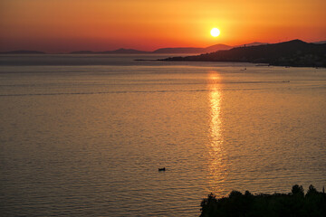 A boat against the backdrop of the setting sun in the port