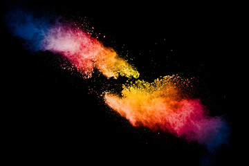 Freeze motion of colorful dust particles splash. Painted Holi powder.