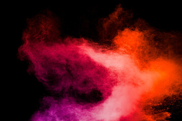 Red pink color powder explosion on black background.Freeze motion of red dust particles splashing.