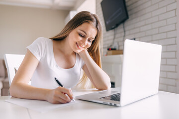 Fototapeta premium Young professional woman, trainee student noting in notebook, freelance copywriter freelancer making list planning tasks.