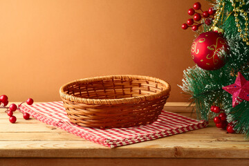 Empty basket on wooden table with tablecloth and Christmas tree. Christmas background for mock up...