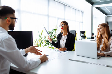 Business professionals. Group of young confident business people working together in the office at the table with a laptop, business concept, business team
