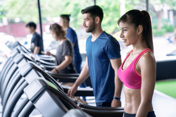 Fototapeta na wymiar Group of people Walking on treadmill or running machine in modern fitness gym.