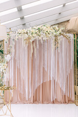 wedding photo zone. white tulle and beige curtain decorated with
