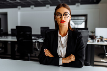 Attractive young business woman sitting at work table in office, business, success concept © Shopping King Louie