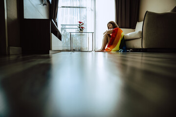 Asian girl and rainbow flag, Young lesbian sit alone in living room.