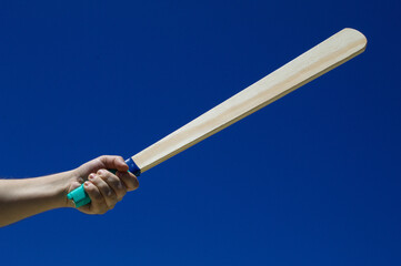 Taco de madeira com fundo do céu azul na mão de uma jogador