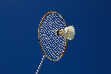 Raquete de badminton com peteca e fundo do céu azul