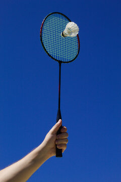 Raquete de badminton com peteca e fundo do c&eacute;u azul
