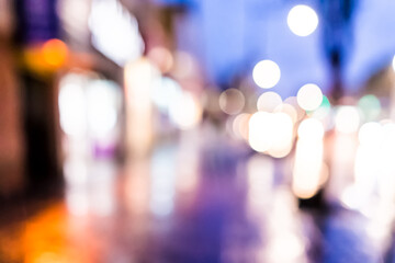 Abstract bokeh background of New York City Manhattan NYC Bronx Fordham heights street at twilight purple evening during rainy day with reflection of sidewalk, car lights