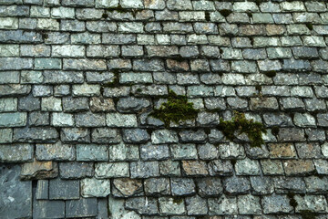 The detail of the old medieval slate roof on a very old house. 