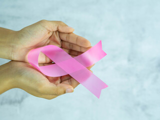 Hands hold pink ribbons. Breast cancer awareness, abdominal cancer awareness , world cancer day.