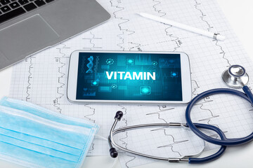 Tablet pc and medical stuff with VITAMIN inscription, prevention concept