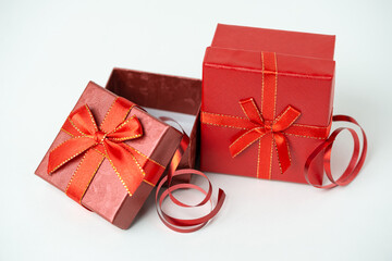 Red gift box with ribbon and bow on white background. For new year, Christmas, Valentine's day and other holiday compositions